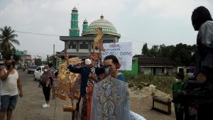 Para seniman berteriak menawaran wayang dan perlengkapan pentas di pinggir jalan depan Pasar Mangu, Kecamatan Ngemplak.